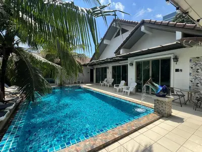 a swimming pool in front of a house at The Snug Airportel - Phuket Airport in Nai Yang Beach