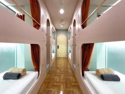 a corridor with two beds in a room at The Snug Airportel - Phuket Airport in Nai Yang Beach