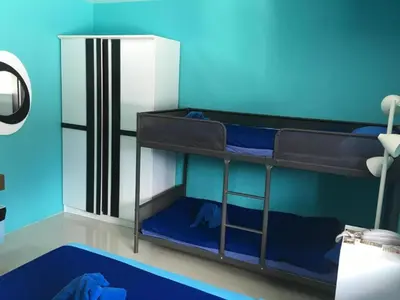 a room with two bunk beds with blue walls at PATONG BLUE HOTEL in Patong Beach
