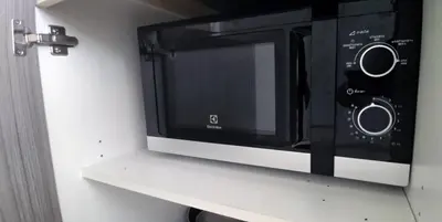 a black and white microwave on a white shelf at KATA BEACH OZONE Superb Fully Equipped studio kitchen washing machine aircon in Kata Beach
