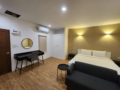 a hotel room with a bed and a desk at Hommory Residence - West Chalong in Ban Klang