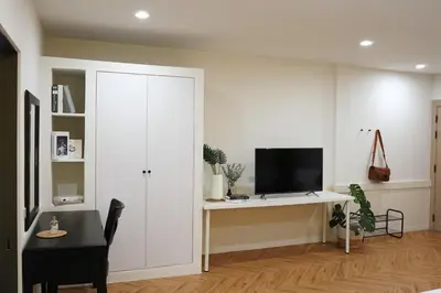a white room with a desk with a tv on it at Hommory Residence - West Chalong in Ban Klang