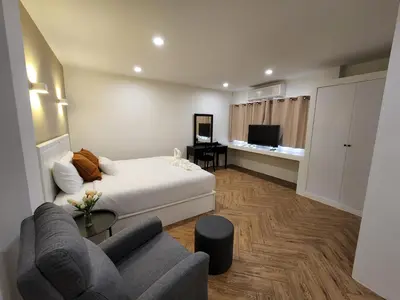 a hotel room with a bed and a couch at Hommory Residence - West Chalong in Ban Klang
