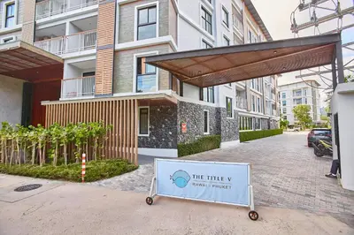 a white sign in front of a building at Title V by Villacarte in Rawai Beach