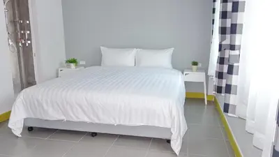 a bedroom with a large white bed with white sheets at Kata Bai D - SHA Certificate Hotel in Kata Beach