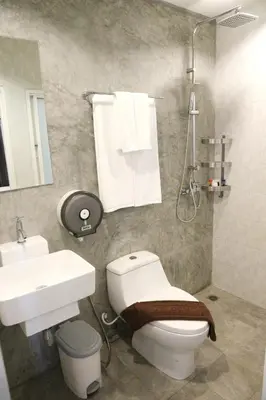 a bathroom with a white toilet and a sink at Kata Bai D - SHA Certificate Hotel in Kata Beach