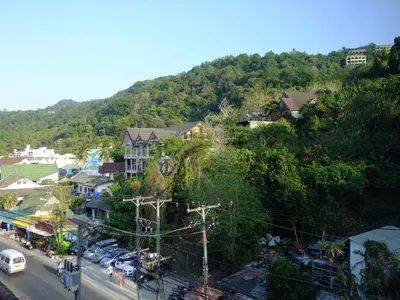 a town on a hill with cars parked on a street at Kata Bai D - SHA Certificate Hotel in Kata Beach