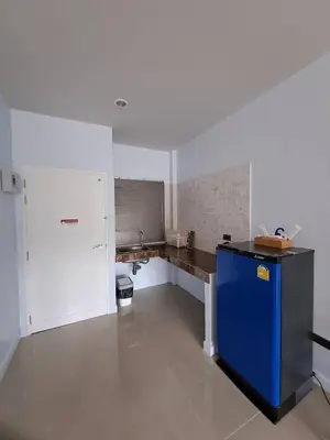 a large white kitchen with a blue counter in it at Triple J Hometel in Bang Tao Beach