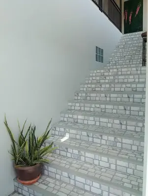 a set of stairs with a potted plant at Triple J Hometel in Bang Tao Beach
