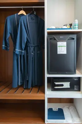 a tv in a closet with a shirt and a shirt at Sira Grande Hotel, Patong in Patong Beach