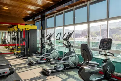 a gym with treadmills and ellipticals in a room with windows at Sira Grande Hotel, Patong in Patong Beach