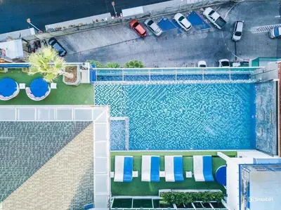 an overhead view of a swimming pool with blue and white chairs at Sira Grande Hotel, Patong in Patong Beach