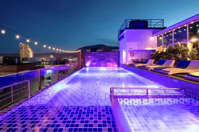 a swimming pool on the roof of a building at night at Sira Grande Hotel, Patong in Patong Beach