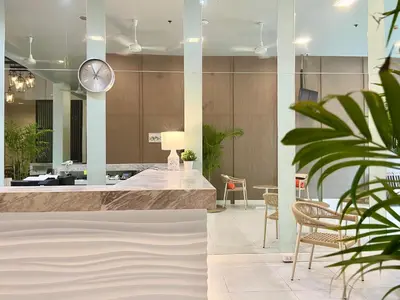a lobby with a clock and a table and chairs at Centro One Patong in Patong Beach