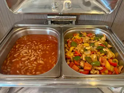 two metal trays of food with beans and vegetables at Centro One Patong in Patong Beach
