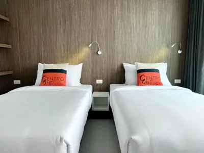 two beds sitting next to each other in a room at Centro One Patong in Patong Beach