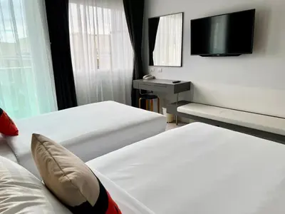 a hotel room with two beds and a television at Centro One Patong in Patong Beach