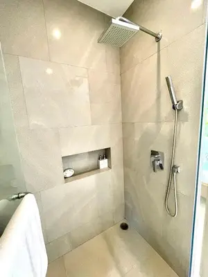 a bathroom with a shower with a glass door at Superbe villa tropicale avec piscine privée Phuket in Phuket Town