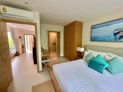 a bedroom with a large bed with blue pillows at Superbe villa tropicale avec piscine privée Phuket in Phuket Town