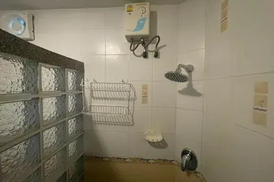 a bathroom with a shower with a blow dryer at Swiss Villas Panoramic - Hillside Beach View in Patong Beach