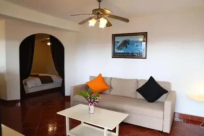 a living room with a couch and a table at Swiss Villas Panoramic - Hillside Beach View in Patong Beach