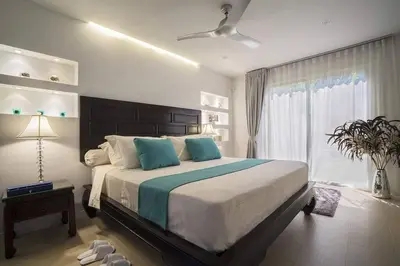a bedroom with a large bed and a window at Villa Nirvana - Beachfront Tropical Chic 4BR Haven in Cape Panwa, Phuket in Ban Ao Makham