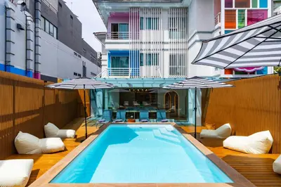 a swimming pool with umbrellas on a building at The Tint At Phuket Town - SHA Plus in Phuket Town