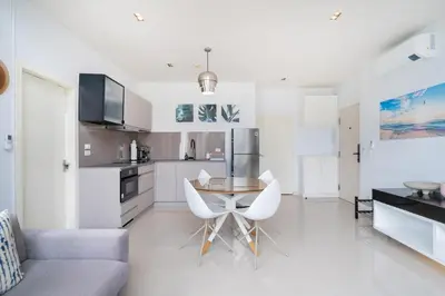 a kitchen and living room with a table and chairs at Deluxe apartment at Icon Park by Lofty in Kamala Beach