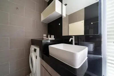 a bathroom with a white sink and a washing machine at Deluxe apartment at Icon Park by Lofty in Kamala Beach