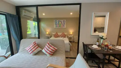 a bedroom with a white bed and a table and a room at Cozy Apartment Close to Amazing Beach ! 39 Sqm in Phuket Town