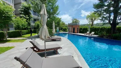 a swimming pool with two lounge chairs and an umbrella at Cozy Apartment Close to Amazing Beach ! 39 Sqm in Phuket Town