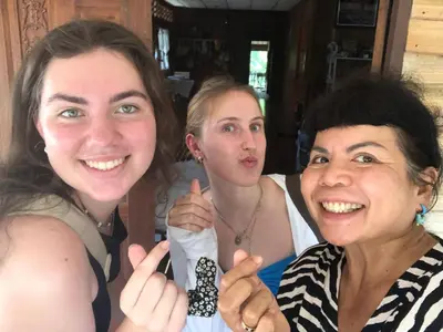 two women giving the thumbs up while holding up a tie at Artist Homestay in Ko Yao Noi