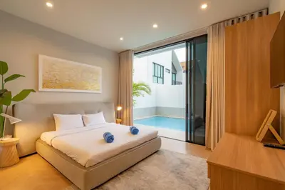 a bedroom with a bed and a view of a pool at Modern 4BR Villa with Private Pool in Bangtao in Bang Tao Beach