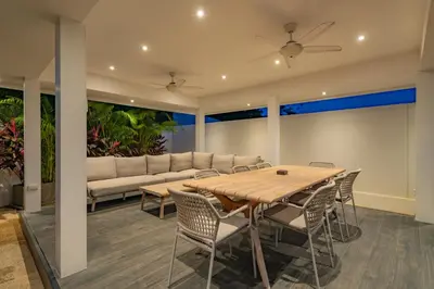 a dining room with a table and chairs and a couch at Modern 4BR Villa with Private Pool in Bangtao in Bang Tao Beach