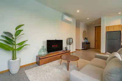 a living room with a couch and a tv at Modern 4BR Villa with Private Pool in Bangtao in Bang Tao Beach