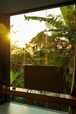 a flat screen tv sitting in front of a window at Romantic villa in the tropics near Kamala Beach in Kamala Beach