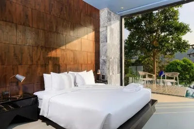 a bedroom with a large white bed and a balcony at Romantic villa in the tropics near Kamala Beach in Kamala Beach