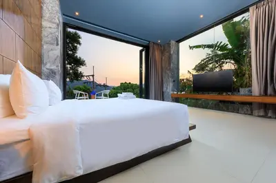 a bedroom with a large white bed and a large window at Romantic villa in the tropics near Kamala Beach in Kamala Beach