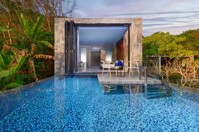 a pool with a table and chairs in a house at Romantic villa in the tropics near Kamala Beach in Kamala Beach