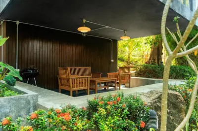 a patio with a table and chairs and flowers at Seclusion in the mountains, villa near Kamala beach in Kamala Beach