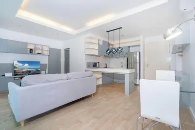 a white living room with a couch and a table at The tree seaview and quiet surrounded by trees 75smetre in Kamala Beach