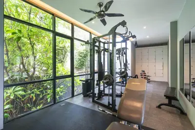 a gym with a large window and a elliptical machine at The tree seaview and quiet surrounded by trees 75smetre in Kamala Beach
