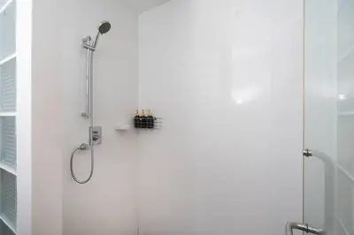 a bathroom with a shower with a glass door at The tree seaview and quiet surrounded by trees 75smetre in Kamala Beach