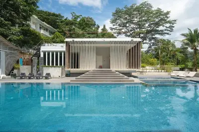 a swimming pool with a house and a building at The tree seaview and quiet surrounded by trees 75smetre in Kamala Beach