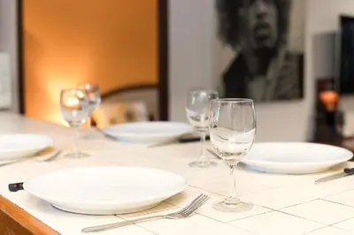 a table with plates and wine glasses on it at Sai Rougn apartment in Patong Beach