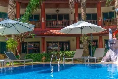 a pool at a resort with a statue of a rabbit and umbrellas at Sai Rougn apartment in Patong Beach