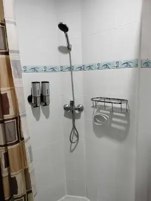 a shower stall with a shower head and a toilet at Sai Rougn apartment in Patong Beach