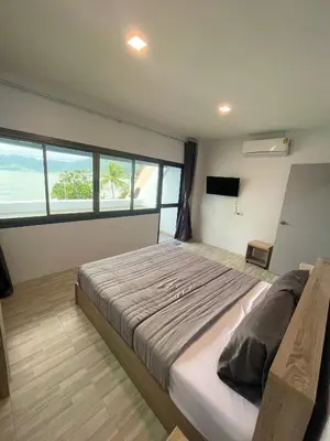a bedroom with a large bed and a large window at Apartment Sea View Patong Beach in Patong Beach
