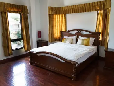 a bedroom with a large bed and two windows at 4BD Private pool villa in Patong heart quiet&nice in Patong Beach