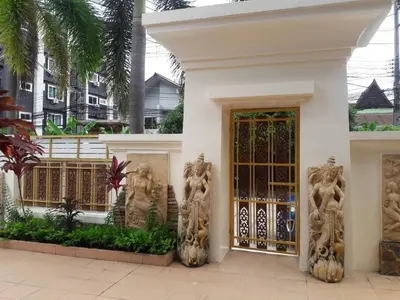 a white house with a door with statues on it at 4BD Private pool villa in Patong heart quiet&nice in Patong Beach